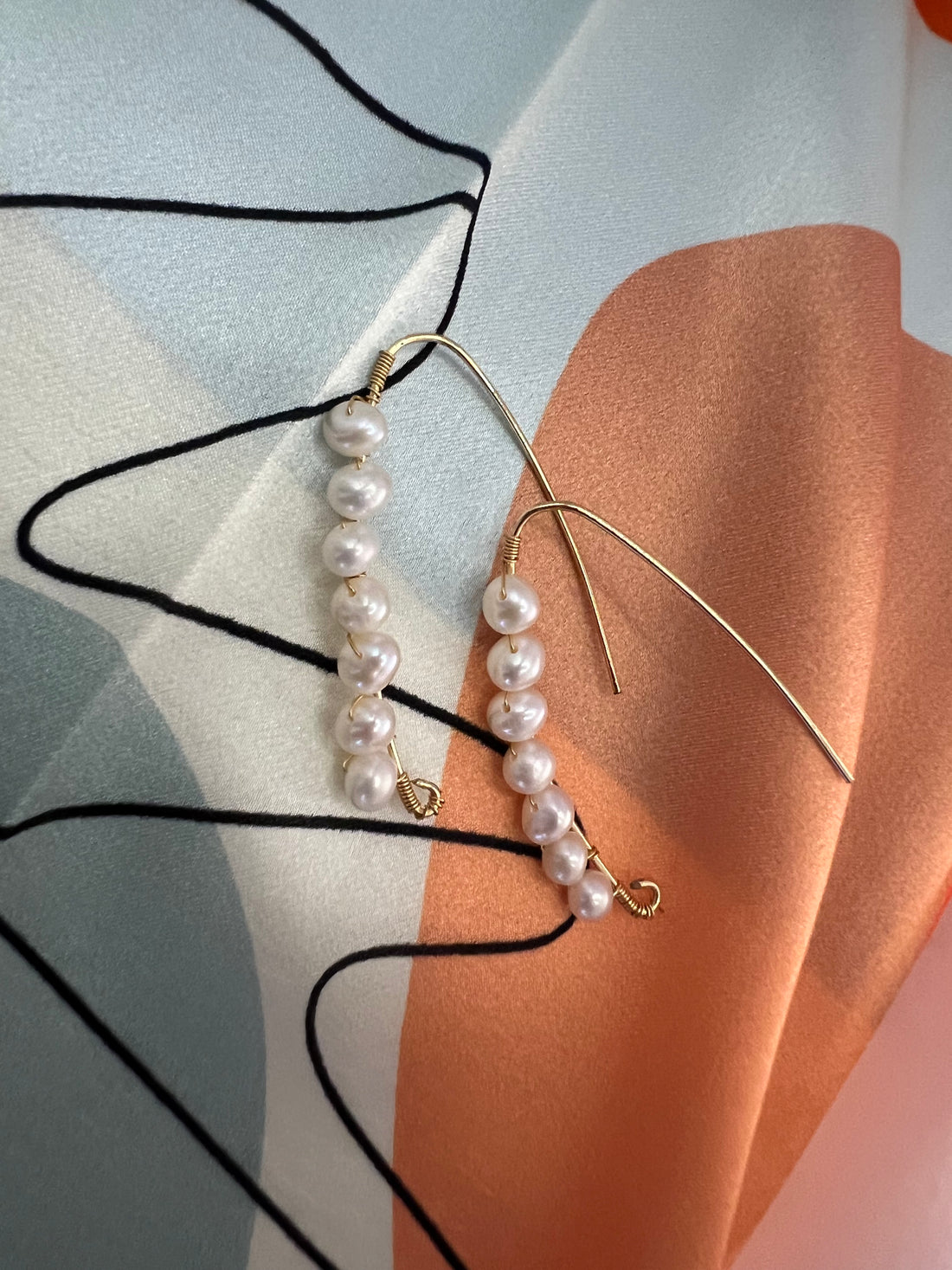 Une paire de boucles d’oreilles en or laminé 14k, ornée d’un bouquet de perles. Les perles, soigneusement agencées en grappe, créent un éclat nacré qui s’harmonise parfaitement avec la chaleur de l’or rempli. Ce design à la fois élégant et raffiné ajoute une touche de luxe subtil, idéale pour sublimer aussi bien les occasions spéciales que les tenues sophistiquées du quotidien